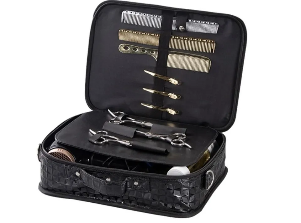 An open black scissor toolbox holding scissors in sleeves, combs and clips, with bulkier tools in the base.