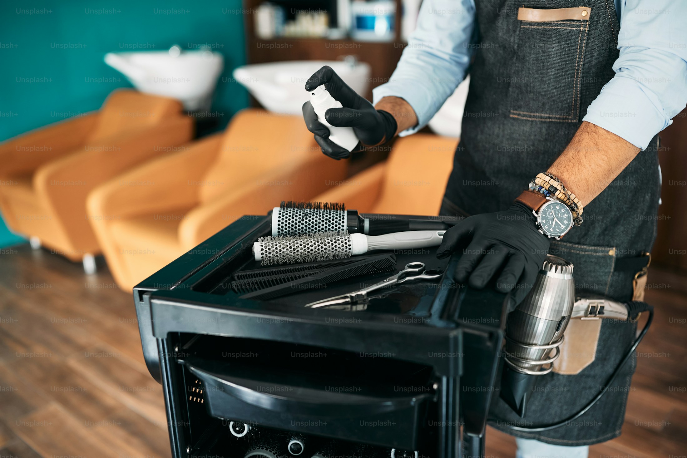 Hairdresser disinfecting scissors and tools after a client